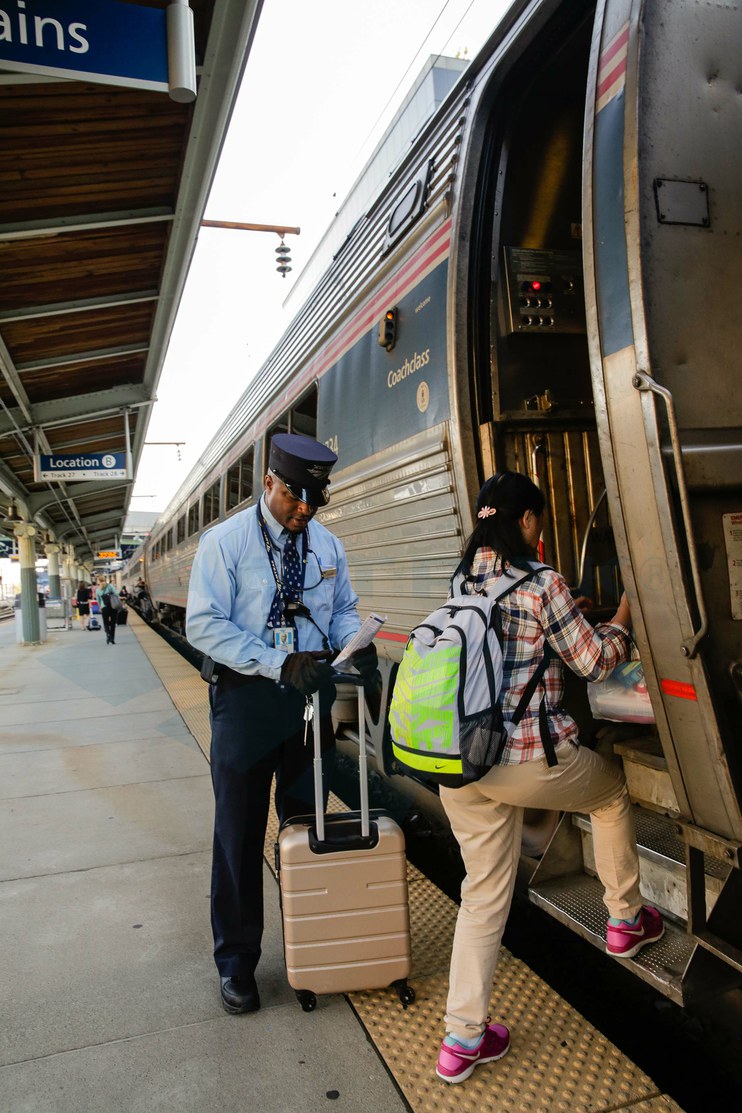 Assistant conductor helping a passenger board the <i>Vermonter</i>, 2015.