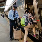 Assistant conductor helping a passenger board the <i>Vermonter</i>, 2015.