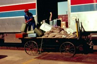 1970s: Baggage Handlers loading from a cart.